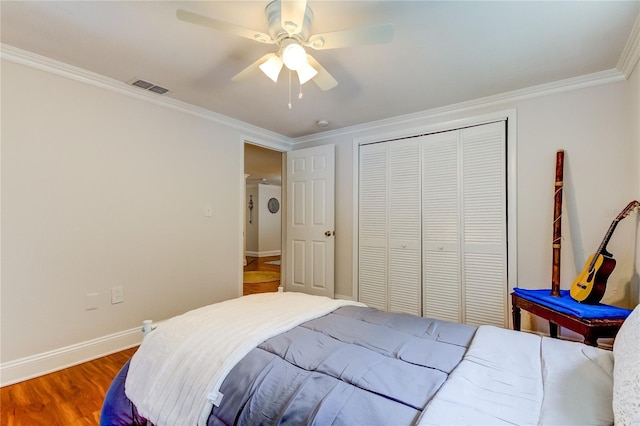 bedroom featuring ceiling fan, a closet, ornamental molding, and hardwood / wood-style flooring