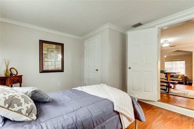 bedroom with crown molding and hardwood / wood-style floors