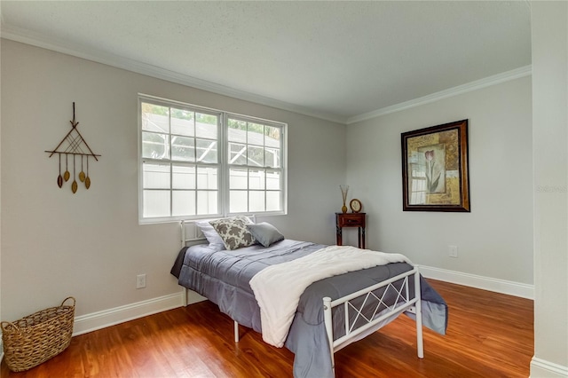 bedroom with hardwood / wood-style floors and ornamental molding