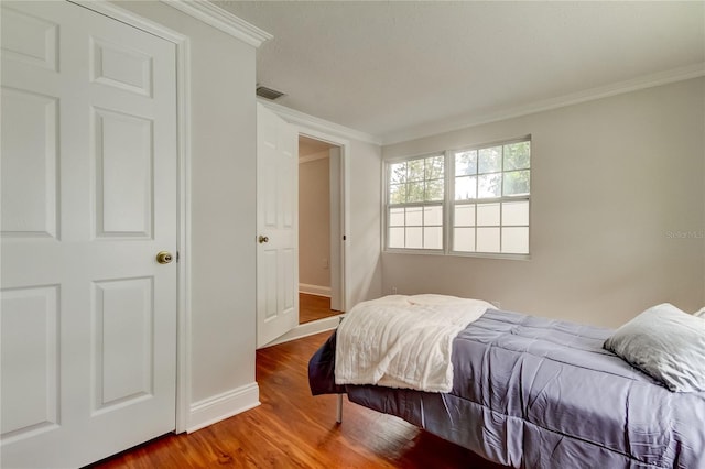 bedroom featuring hardwood / wood-style flooring and ornamental molding