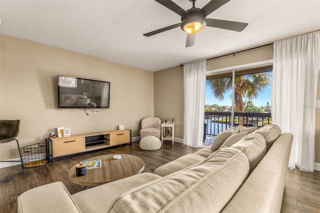 living room featuring ceiling fan and dark hardwood / wood-style floors