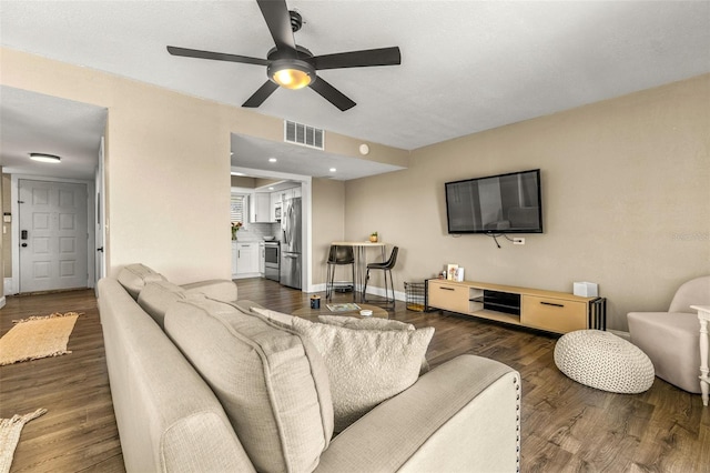 living room featuring ceiling fan and dark hardwood / wood-style flooring