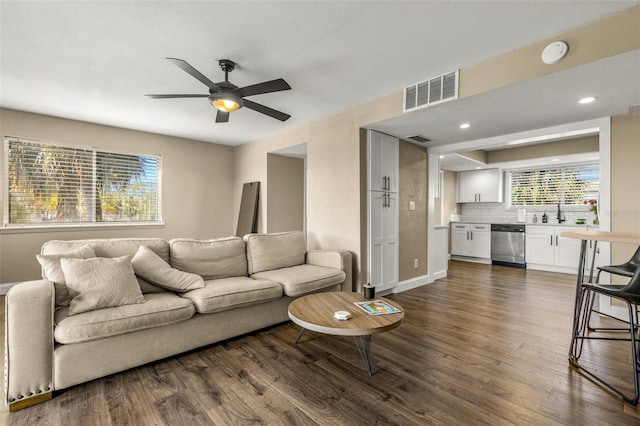 living room featuring ceiling fan and dark wood-type flooring