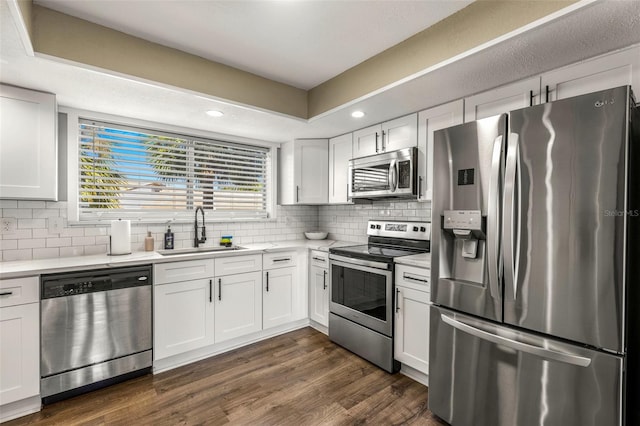 kitchen featuring appliances with stainless steel finishes, white cabinetry, and sink