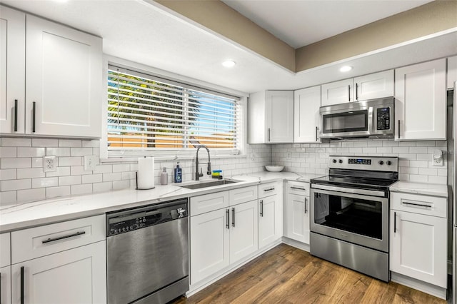 kitchen featuring white cabinetry, sink, dark hardwood / wood-style flooring, backsplash, and appliances with stainless steel finishes