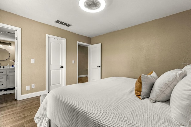 bedroom featuring hardwood / wood-style floors and connected bathroom