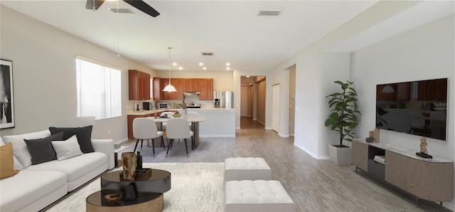 living room with light hardwood / wood-style floors and ceiling fan