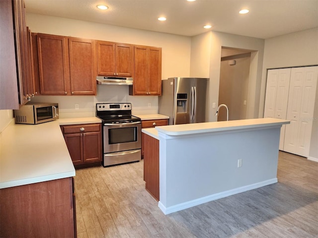 kitchen with sink, a center island with sink, light hardwood / wood-style flooring, and appliances with stainless steel finishes