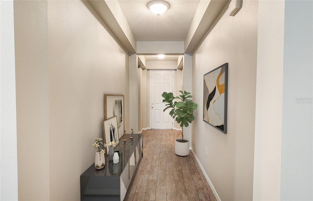 hall featuring hardwood / wood-style floors and a textured ceiling