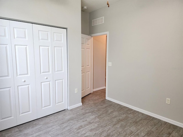 unfurnished bedroom with light hardwood / wood-style floors and a closet