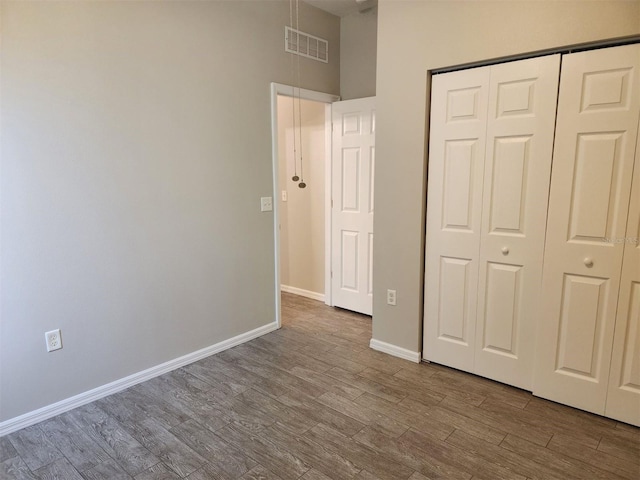 unfurnished bedroom featuring hardwood / wood-style flooring and a closet