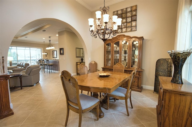 tiled dining space featuring ornamental molding and a chandelier