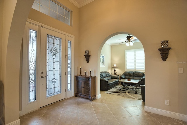 foyer with ornamental molding and light tile patterned flooring