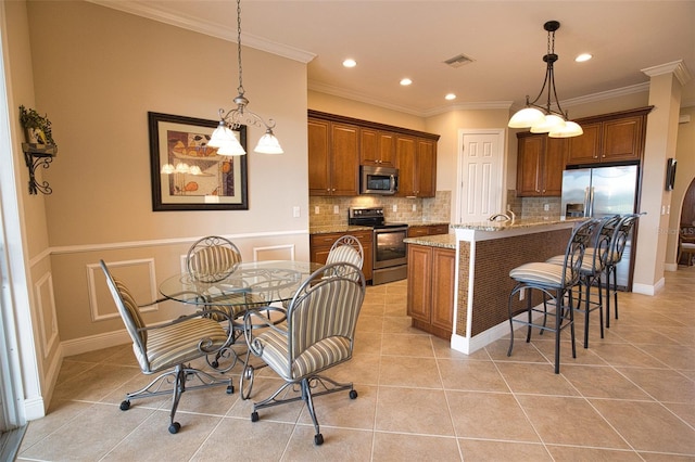 kitchen featuring light stone counters, decorative light fixtures, a center island with sink, light tile patterned floors, and stainless steel appliances