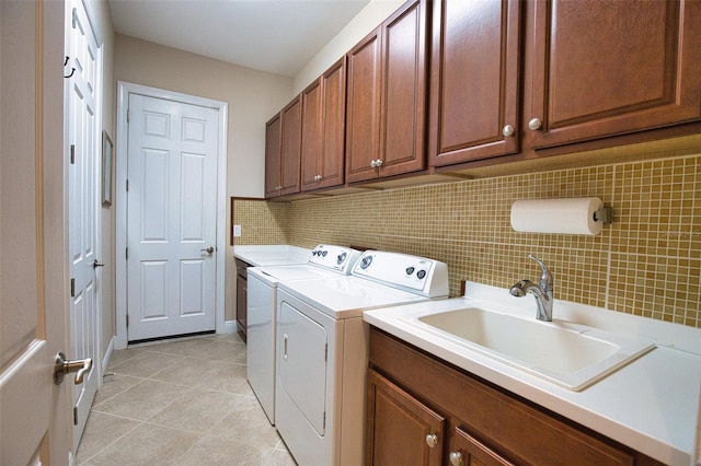 clothes washing area with sink, independent washer and dryer, light tile patterned floors, and cabinets