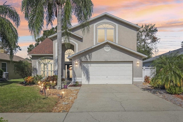 front of property featuring a lawn and a garage