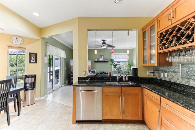 kitchen featuring dishwasher, ceiling fan, dark stone counters, and sink