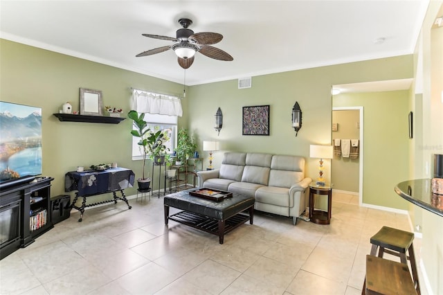 living room with ceiling fan, light tile patterned flooring, and ornamental molding