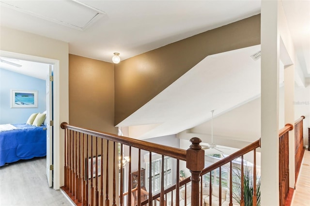 hallway with light hardwood / wood-style flooring and vaulted ceiling