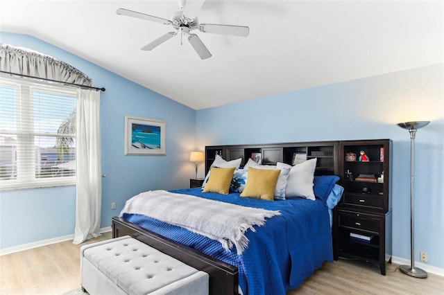 bedroom with ceiling fan, light hardwood / wood-style flooring, and vaulted ceiling