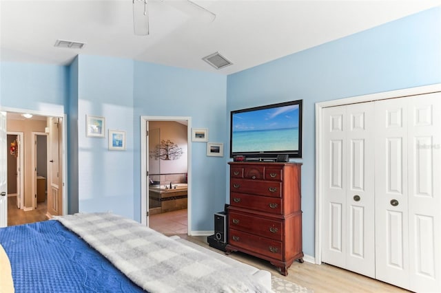 bedroom featuring ensuite bathroom, a closet, ceiling fan, and light wood-type flooring