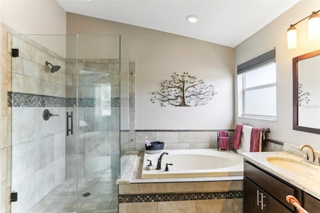 bathroom featuring plus walk in shower, vanity, and lofted ceiling