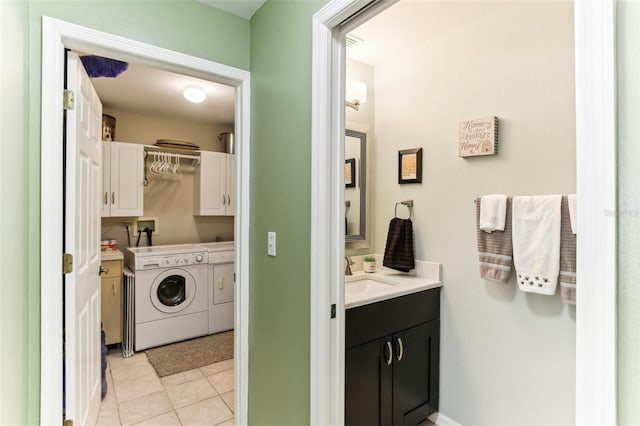 laundry area with cabinets, light tile patterned floors, and washing machine and dryer