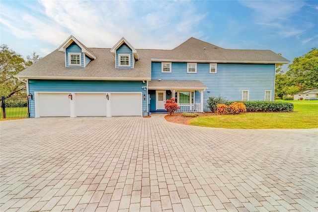 view of front facade with a front lawn, a porch, and a garage