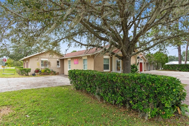 single story home featuring a garage and a front lawn