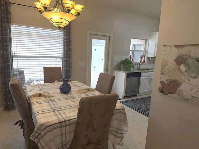 tiled dining area with a chandelier, lofted ceiling, a healthy amount of sunlight, and sink