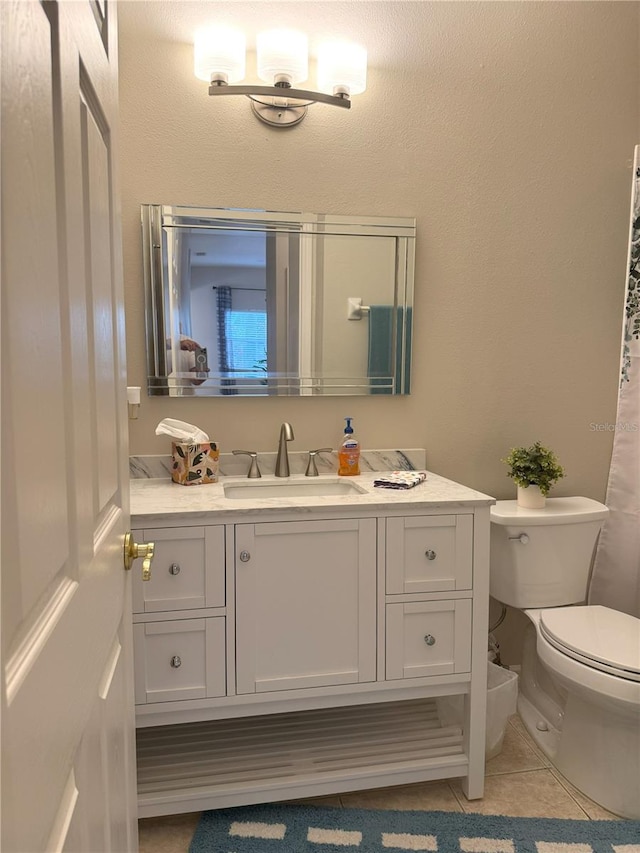 bathroom featuring toilet, vanity, and tile patterned floors