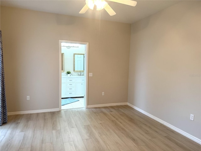 empty room featuring ceiling fan, sink, and light hardwood / wood-style floors