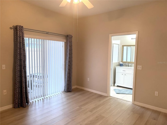 spare room with ceiling fan, sink, and light wood-type flooring