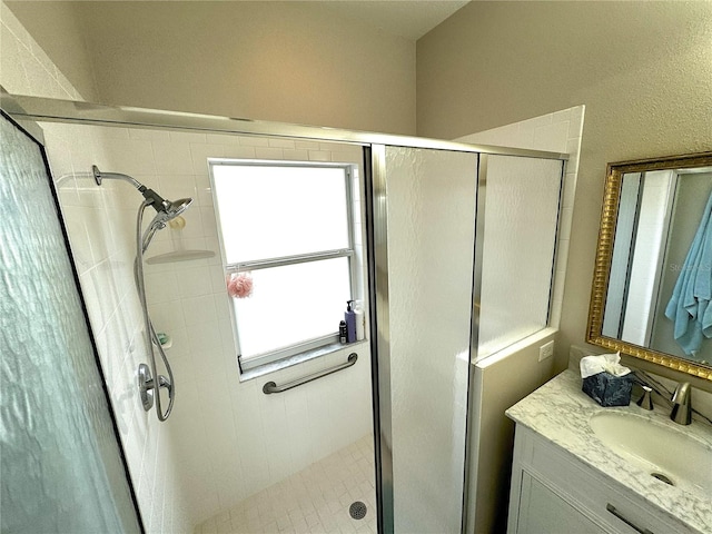 bathroom with vanity and a shower with shower door