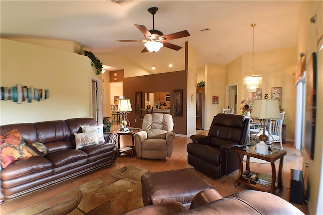 living room with wood-type flooring, ceiling fan with notable chandelier, and high vaulted ceiling