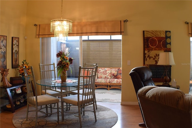 dining area featuring wood-type flooring and an inviting chandelier