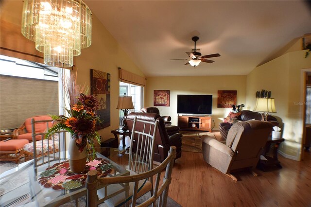 dining area with ceiling fan, hardwood / wood-style floors, and vaulted ceiling