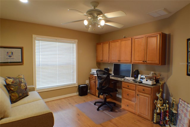 home office with built in desk, light hardwood / wood-style flooring, and ceiling fan