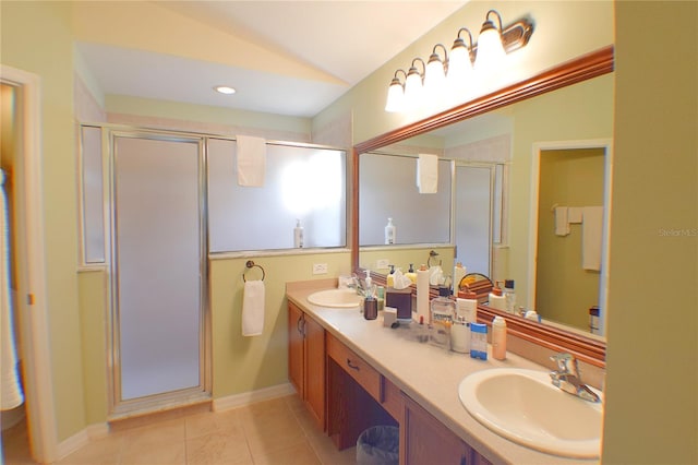 bathroom with tile patterned floors, vanity, a shower with shower door, and vaulted ceiling