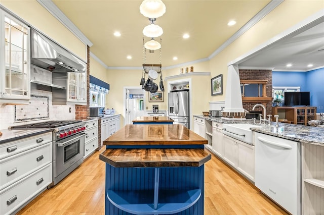 kitchen featuring white cabinetry, stainless steel appliances, wood counters, a kitchen island, and light wood-type flooring