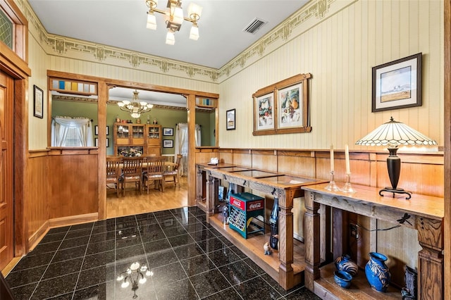 interior space with hardwood / wood-style floors, wood walls, and a chandelier