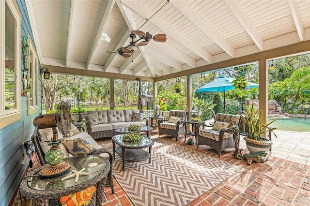 sunroom / solarium featuring beamed ceiling and ceiling fan