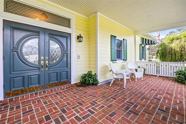 doorway to property featuring covered porch and french doors