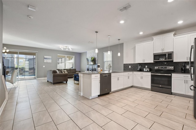 kitchen with pendant lighting, white cabinetry, kitchen peninsula, and appliances with stainless steel finishes