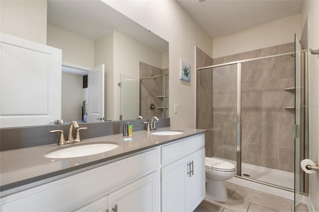 bathroom with tile patterned floors, vanity, toilet, and walk in shower