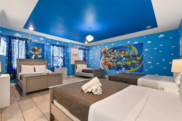 bedroom featuring light tile patterned flooring and a raised ceiling