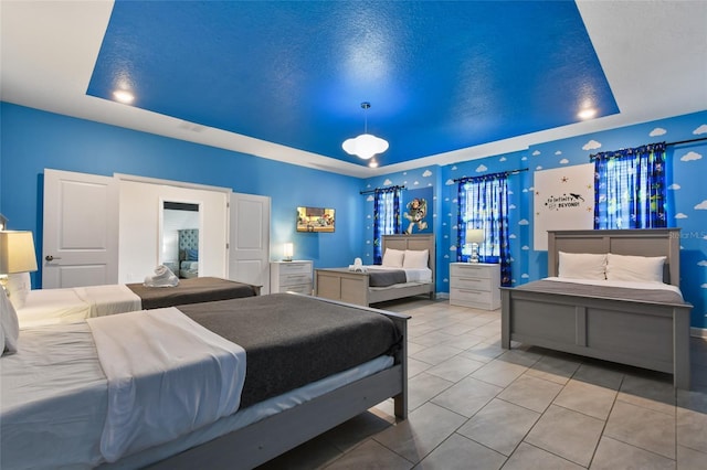 tiled bedroom with a raised ceiling and a textured ceiling