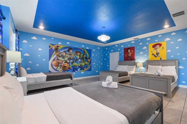 bedroom with light tile patterned floors and a raised ceiling