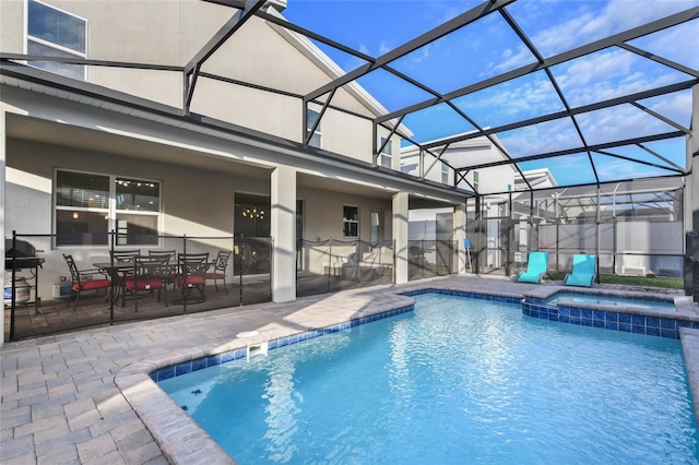 view of swimming pool featuring glass enclosure, an in ground hot tub, and a patio