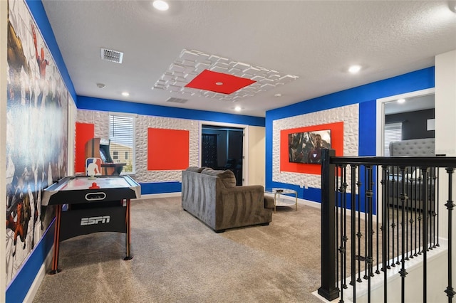 rec room with carpet and a textured ceiling